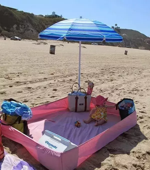 Use an elastic bed sheet to keep your kids close to you when you're at the beach. Add an umbrella for sun protection.